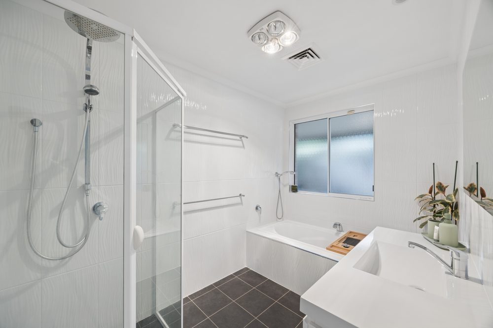 Main bathroom with bath, shower and floor-to-ceiling tiles