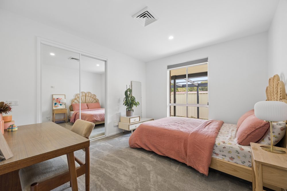 Bedroom with built-in mirrored robes and a desk