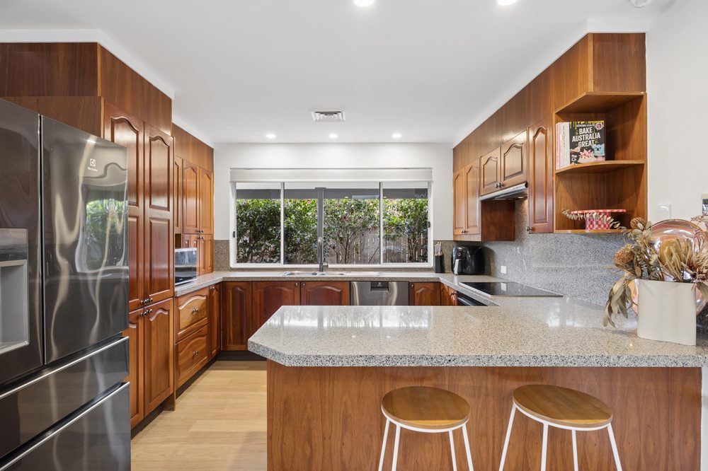Kitchen with granite benchtops, timber cabinetry and a breakfast bar